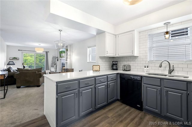 kitchen featuring pendant lighting, sink, dishwasher, white cabinets, and kitchen peninsula