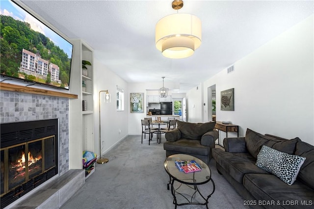 carpeted living room featuring built in shelves and a fireplace