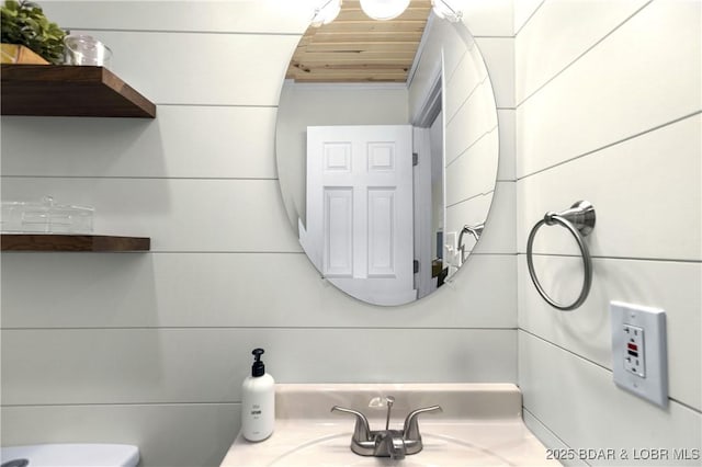 bathroom with sink, wooden ceiling, and toilet