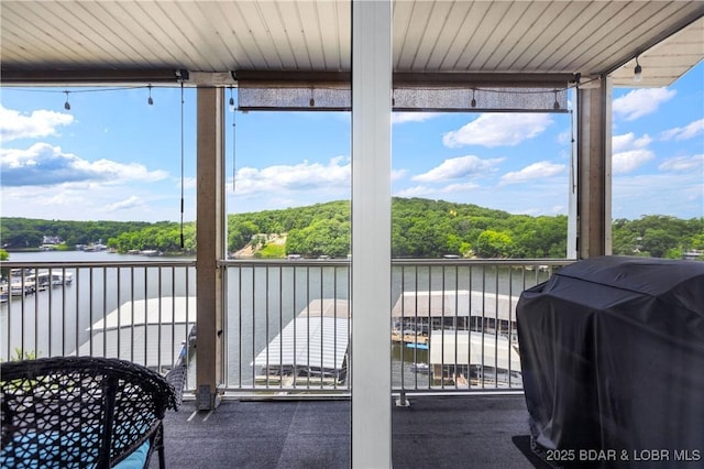 sunroom featuring a water view