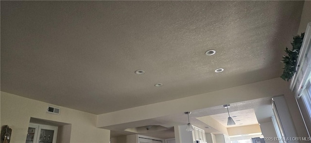 interior details with a textured ceiling, visible vents, and recessed lighting