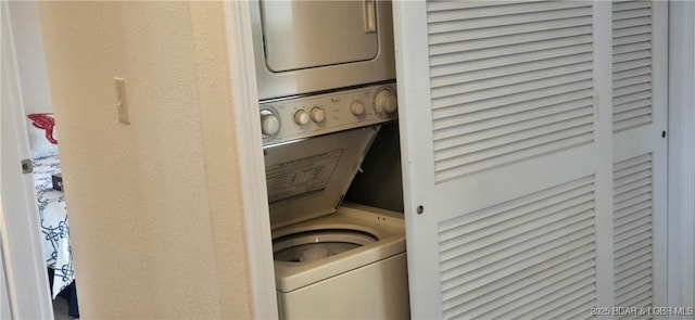 washroom featuring stacked washer and clothes dryer