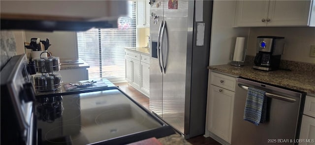 kitchen featuring stainless steel appliances, light stone countertops, and white cabinets