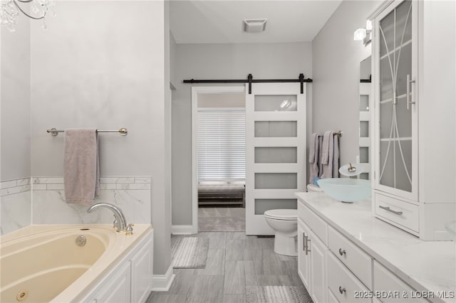 bathroom with vanity, a washtub, and toilet