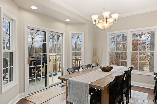 dining area with an inviting chandelier, hardwood / wood-style flooring, and crown molding