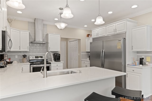 kitchen featuring white cabinets, stainless steel appliances, kitchen peninsula, and wall chimney range hood