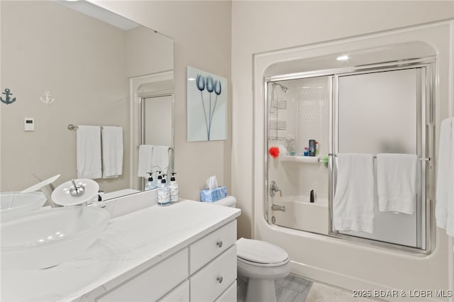 full bathroom with enclosed tub / shower combo, vanity, and toilet