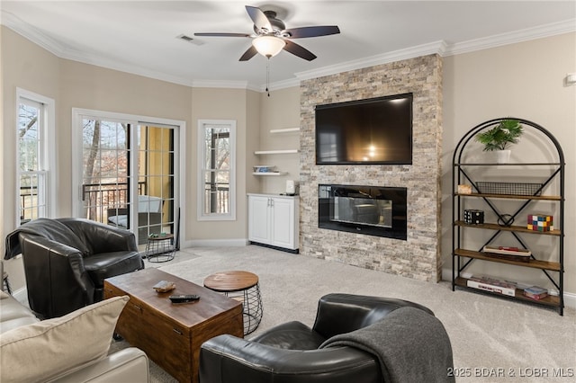 carpeted living room with crown molding, a stone fireplace, and ceiling fan