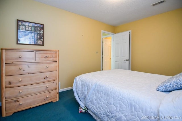 bedroom with dark carpet and a textured ceiling