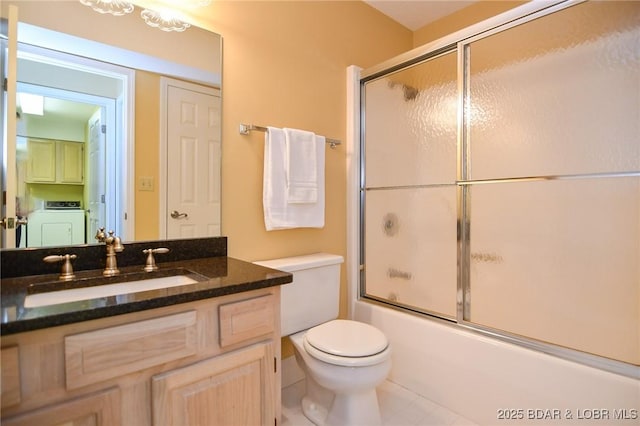 full bathroom featuring vanity, washer / dryer, enclosed tub / shower combo, and toilet