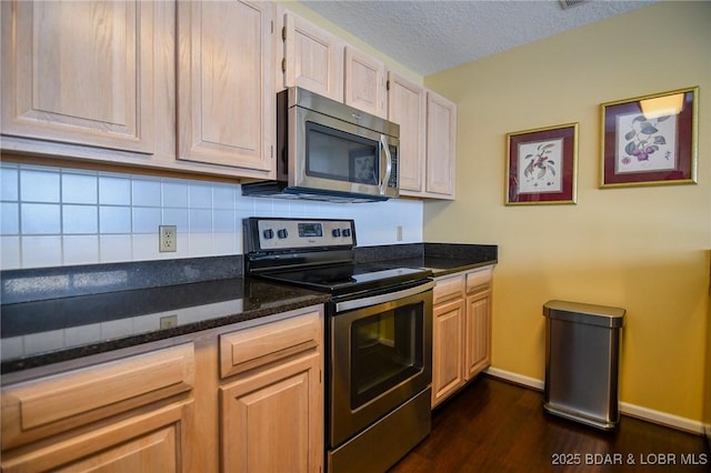 kitchen featuring tasteful backsplash, a textured ceiling, dark stone countertops, light brown cabinets, and appliances with stainless steel finishes