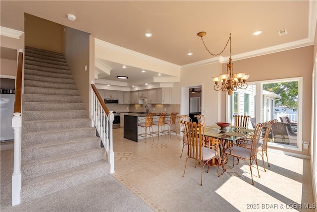 dining space featuring sink, ornamental molding, a chandelier, and light tile patterned flooring