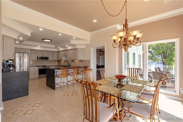 dining room with ornamental molding, sink, light tile patterned floors, and a chandelier