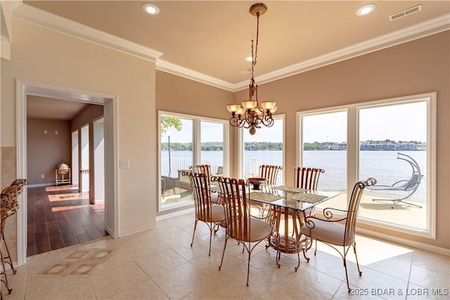 dining space with ornamental molding, a water view, light tile patterned floors, and a chandelier