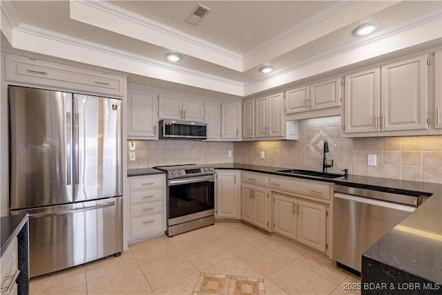 kitchen with sink, crown molding, stainless steel appliances, decorative backsplash, and a raised ceiling