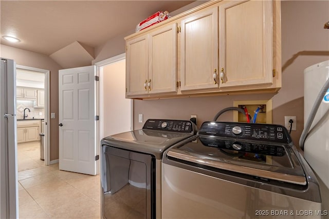 laundry area featuring washer and dryer, sink, light tile patterned floors, and cabinets