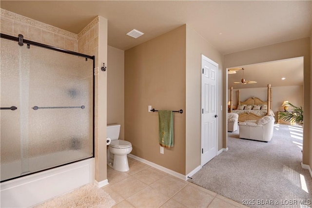 bathroom featuring combined bath / shower with glass door, tile patterned floors, and toilet