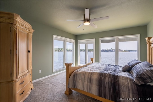 carpeted bedroom with a water view and ceiling fan