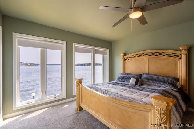 carpeted bedroom with a water view and ceiling fan