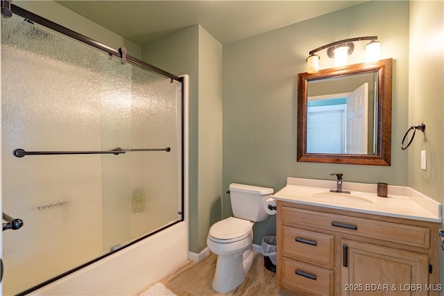 full bathroom with vanity, shower / bath combination with glass door, and toilet