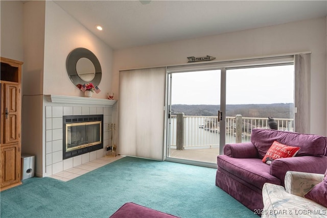 living room featuring lofted ceiling, a fireplace, and light colored carpet