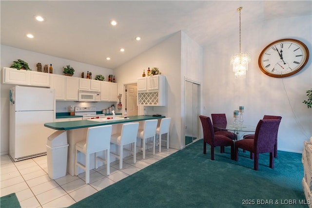 kitchen featuring a breakfast bar, sink, high vaulted ceiling, white appliances, and white cabinets