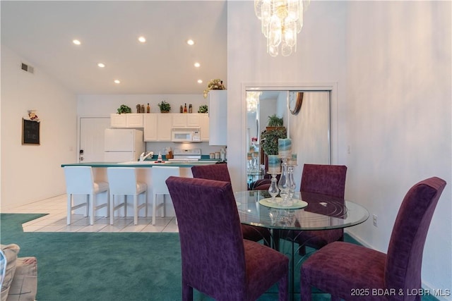 carpeted dining room with a towering ceiling and a chandelier