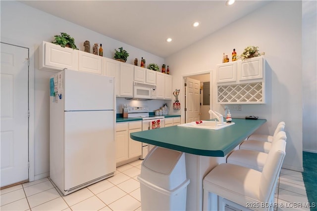 kitchen with white cabinetry, lofted ceiling, sink, a kitchen breakfast bar, and white appliances