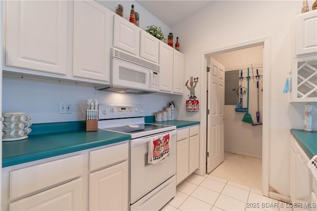 kitchen with white cabinetry, light tile patterned floors, and white appliances