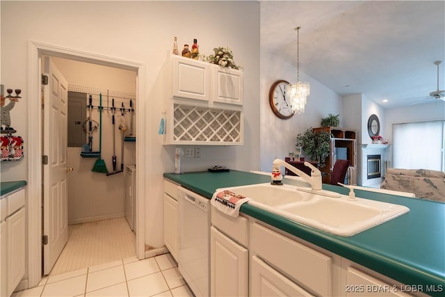 kitchen with sink, hanging light fixtures, light tile patterned floors, white dishwasher, and white cabinets