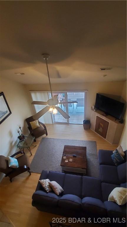 living room featuring ceiling fan and light wood-type flooring