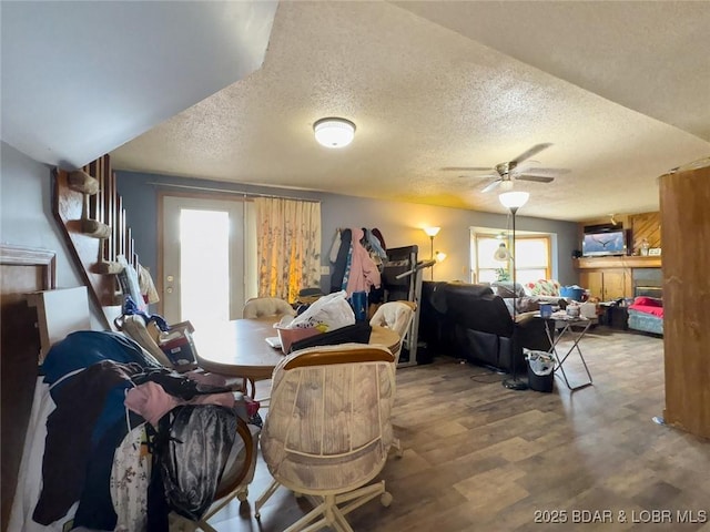 dining space with hardwood / wood-style flooring, ceiling fan, and a textured ceiling