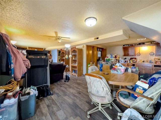 dining space with ceiling fan, wood-type flooring, and a textured ceiling