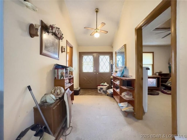 entryway featuring vaulted ceiling, light colored carpet, french doors, and ceiling fan