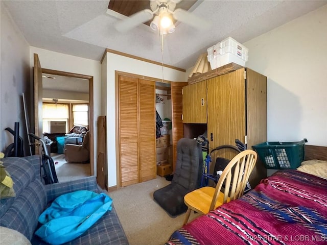 bedroom with ceiling fan, a closet, carpet flooring, and a textured ceiling