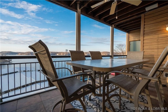 sunroom / solarium featuring a water view and ceiling fan