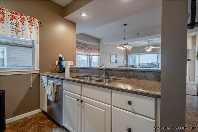 kitchen featuring white cabinetry, stainless steel dishwasher, ceiling fan with notable chandelier, and sink