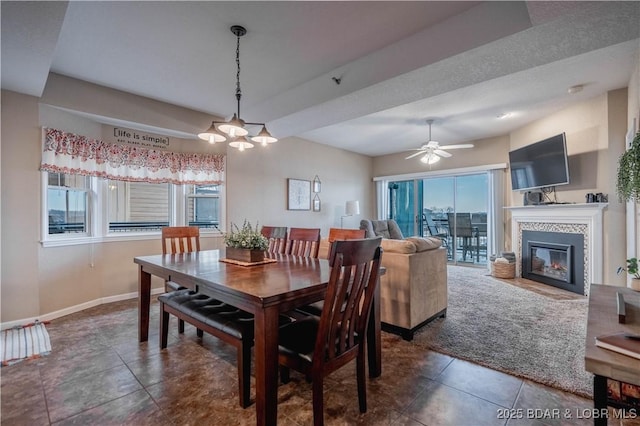 tiled dining room featuring ceiling fan, plenty of natural light, and a fireplace