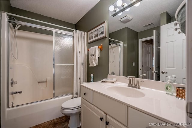 full bathroom with bath / shower combo with glass door, vanity, a textured ceiling, and toilet