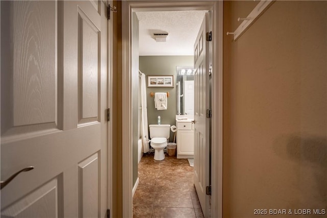 bathroom featuring vanity, a textured ceiling, and toilet