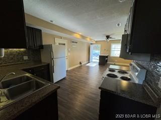 kitchen featuring sink, tasteful backsplash, range, white refrigerator, and dark hardwood / wood-style floors