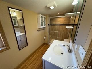 bathroom featuring vanity, a shower with door, and toilet