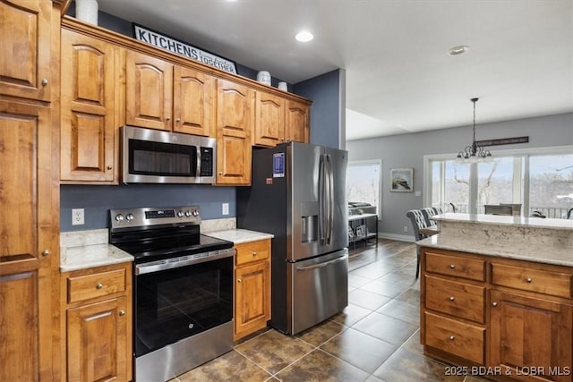 kitchen featuring pendant lighting, stainless steel appliances, a chandelier, and dark tile patterned floors