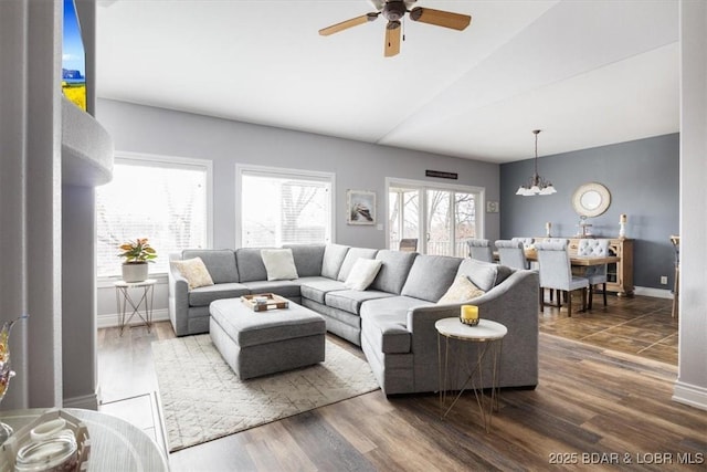 living room featuring lofted ceiling, ceiling fan with notable chandelier, and dark hardwood / wood-style flooring