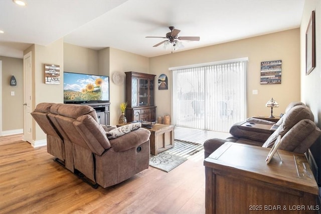 living room featuring ceiling fan and light hardwood / wood-style flooring