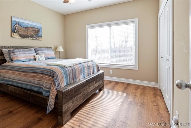 bedroom with hardwood / wood-style flooring, a closet, and ceiling fan