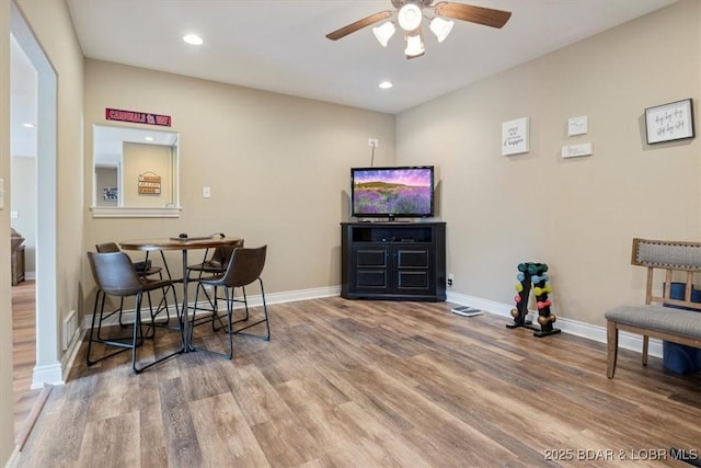 living area featuring wood-type flooring and ceiling fan