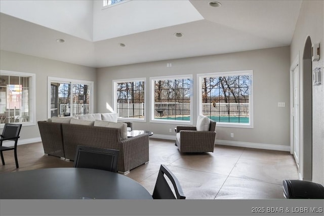 living room featuring a towering ceiling and a healthy amount of sunlight