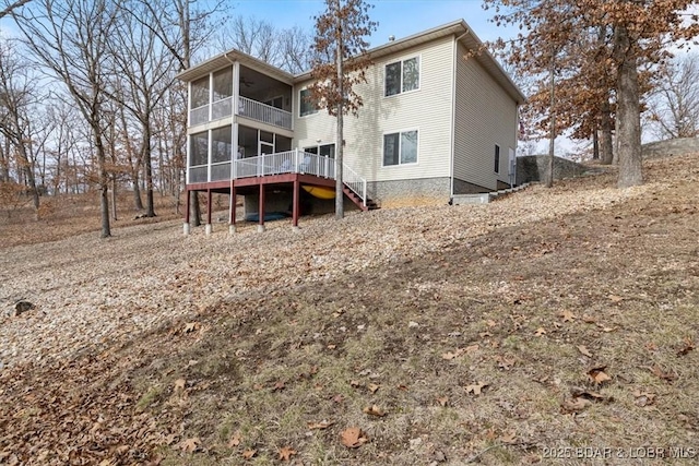 rear view of property featuring a balcony, a deck, and a sunroom