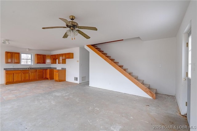 unfurnished living room with sink and ceiling fan